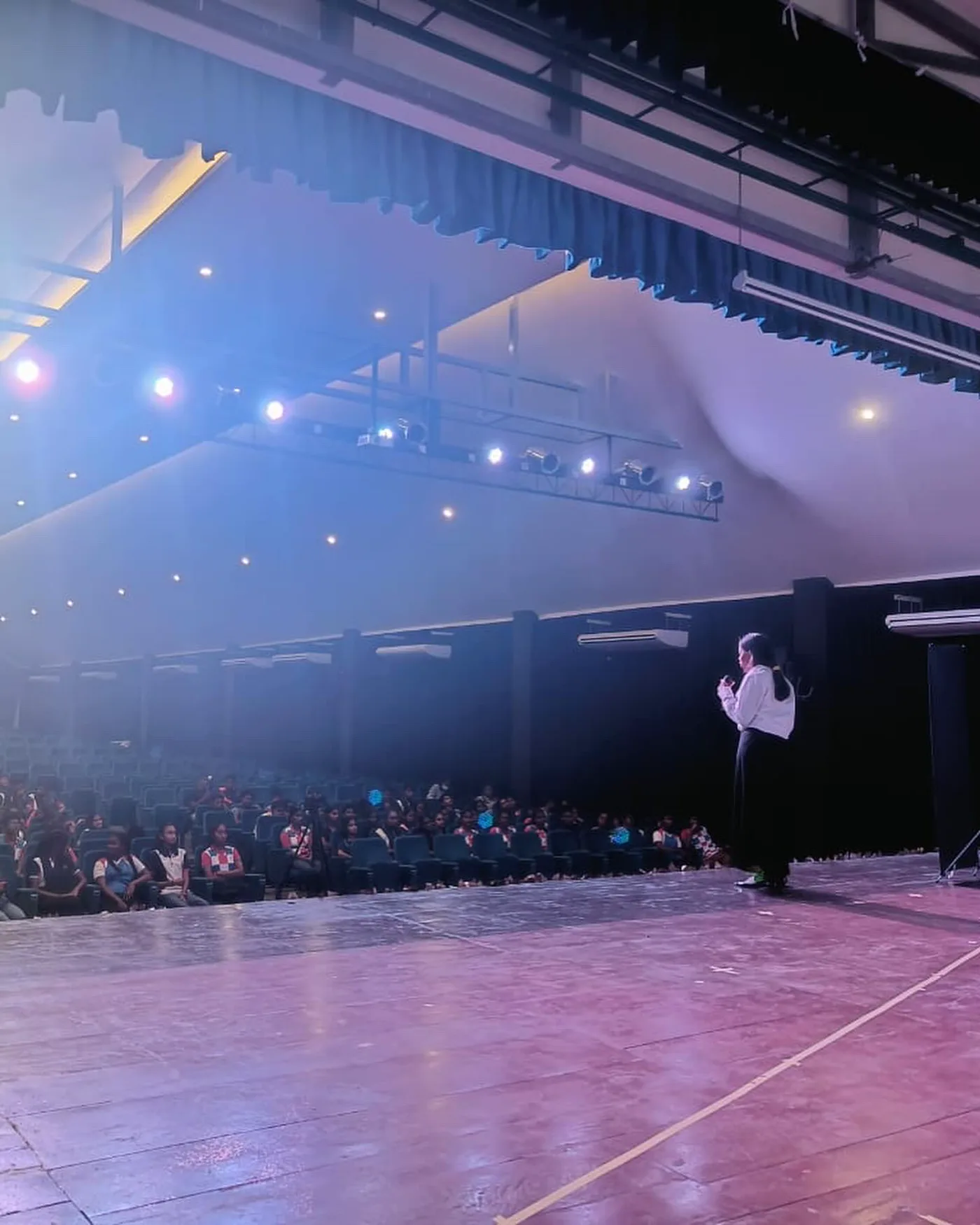 A speaker addressing an auditorium audience